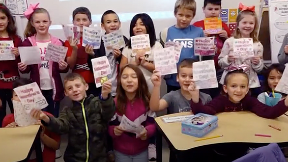 A Boerne Texas classroom of children proudly display their card art meant for foster kids