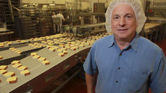 THRU Project Co-Founder Steve O'Donnell pictured in hairnet in front of his bakery manufacturing assembly line