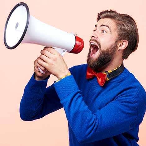 Bearded man shouting enthusiastically into megaphone