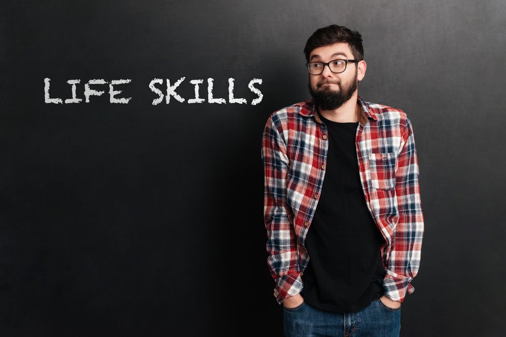 cheerful man wearing glasses standing over chalkboard